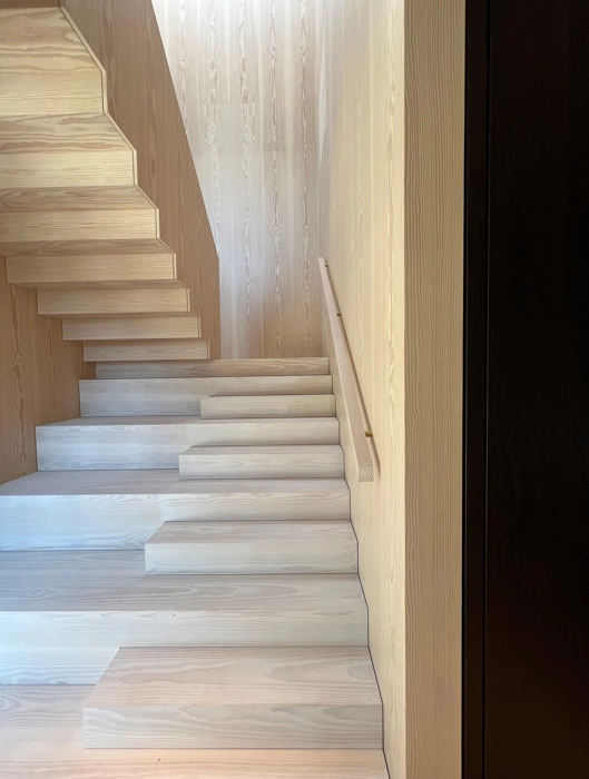Specialdesignet trappe til villa fra snedkeri i lyst træ douglas med mulighed for siddeplads skaber indretning med personligt præg 