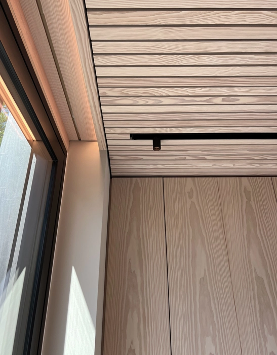 skinne med spots i sort smukt integreret i listeloft i træ, arkitektonisk listeloft