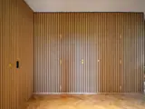 trævæg med lister og med indbyggede døre sådan at væggen fremstår som en smuk helhed, usynlige døre i væg
