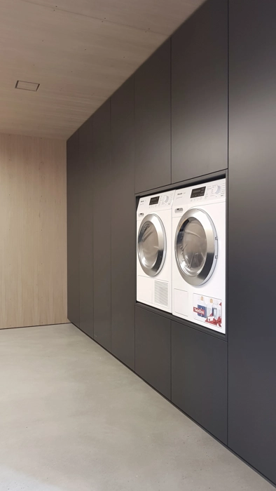 Snedkereret skabsvæg med indbygget vaskemaskine og tørretumbler i smart løsning i god arbejdshøjde 