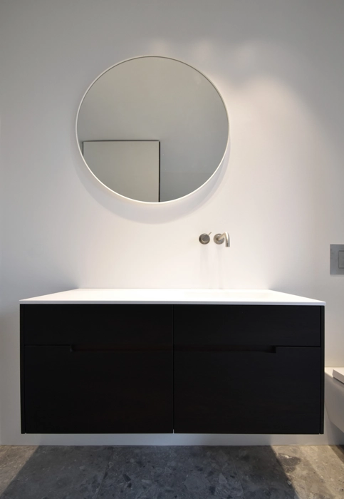 Snedkereret badmøbel med vask i højre side med rundt spejl