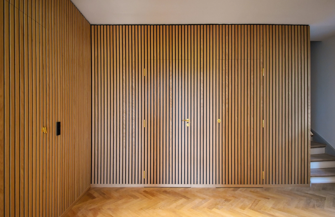 trævæg med lister og med indbyggede døre sådan at væggen fremstår som en smuk helhed, usynlige døre i væg
